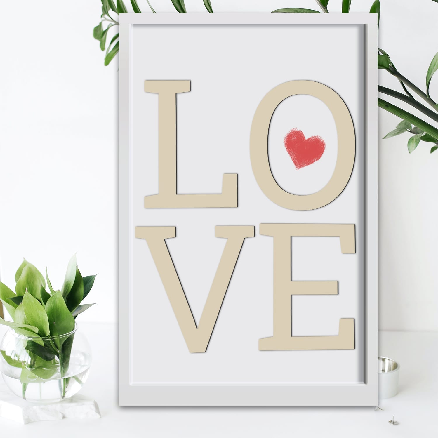 Framed print with the word LOVE, featuring a small red heart.